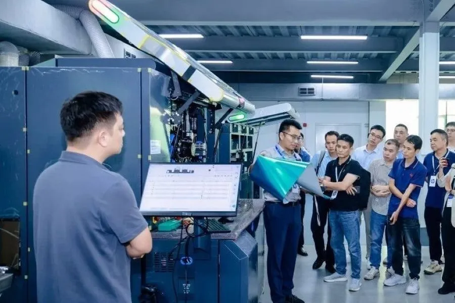 A group of people standing around a machine.